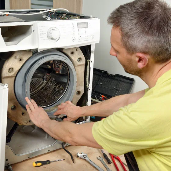 Técnico reparando una lavadora a domicilio en Quito